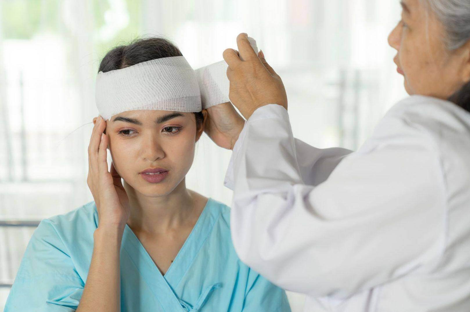 An accident doctor bandaging a car accident victims head in Jersey City, New Jersey