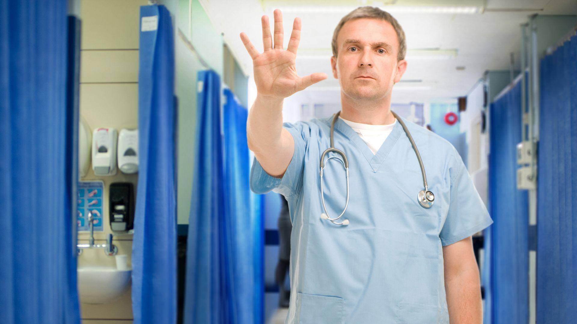An emergency room doctor stops a patient from moving in an ER in Chandler, Arizona